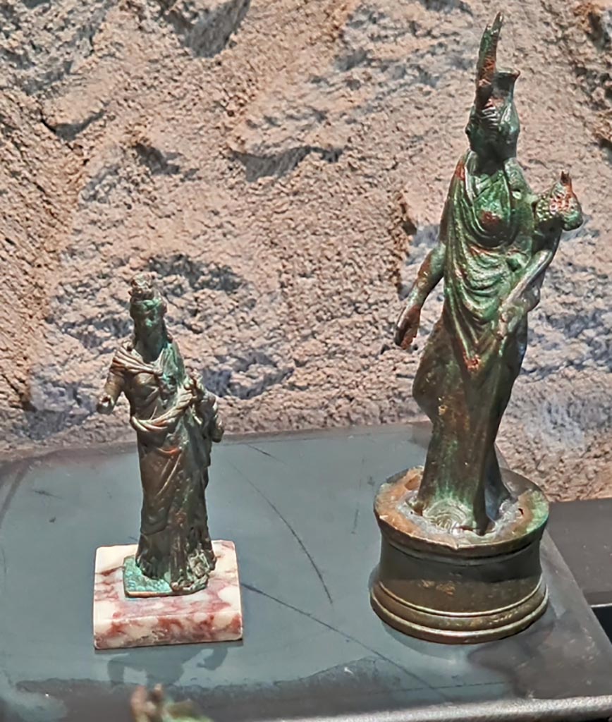 Civita Giuliana, Imperial Villa, March 2024. Two statuettes from the Isiac lararium. Photo courtesy of Giuseppe Ciaramella.
2 bronze statuettes of Isis/Fortuna, (1st century AD.) (2, Statuette di Iside/Fortuna, bronzo, (I sec. d.C).
On display in exhibition in Palaestra entitled – “L’altra Pompei, vite comuni all’ombra del Vesuvio”.
