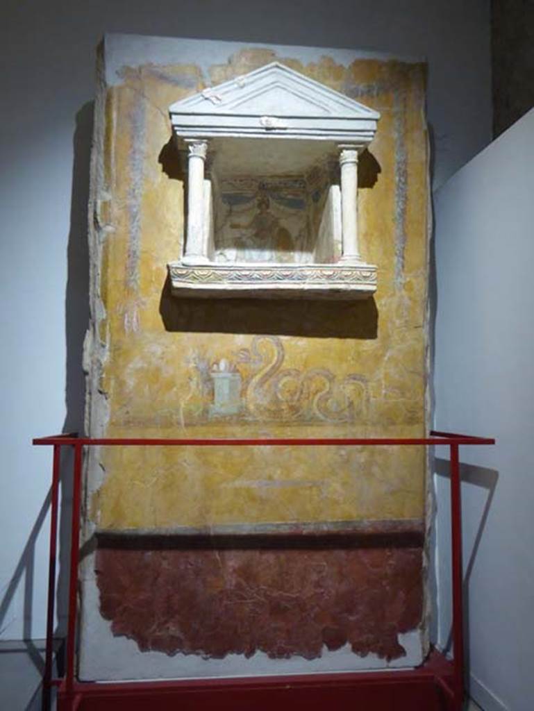 97. Gragnano, Villa rustica in Località Carmiano, Villa A. June 2017. Aedicula lararium. 
From dividing pilaster between kitchen room 4 and room 2. 
Stabiae Antiquarium, inventory number 63688.
Photo courtesy of Michael Binns.
Lararium with niche and painting of serpent underneath. 
The lararium had a triangular pediment supported by two Corinthian columns.
The painting at the rear showed an enthroned Minerva with breastplate, helmet, shield, lance in the left hand and gilded/golden plate in the right. 
Underneath the lararium, a painted serpent was found, moving to the right towards an altar on which was deposited the offerings. 
See Fröhlich, T., 1991. Lararien und Fassadenbilder in den Vesuvstädten. Mainz: von Zabern, p. 303, L122, Taf. 15,1.
