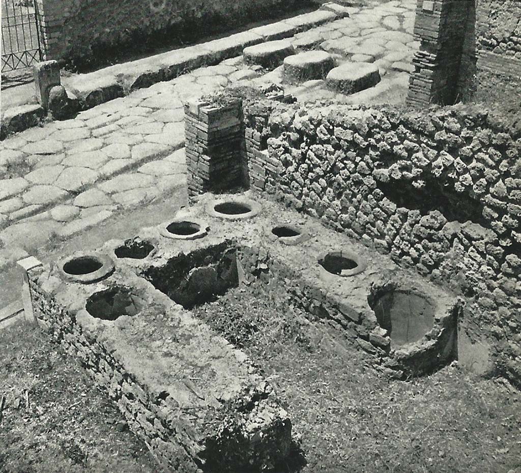 I.3.11 Pompeii. Old undated photograph. Looking west across top of counter towards Via Stabiana.
On the opposite side of the road is the entrance to VIII.7.25, and the fountain outside the doorway.
