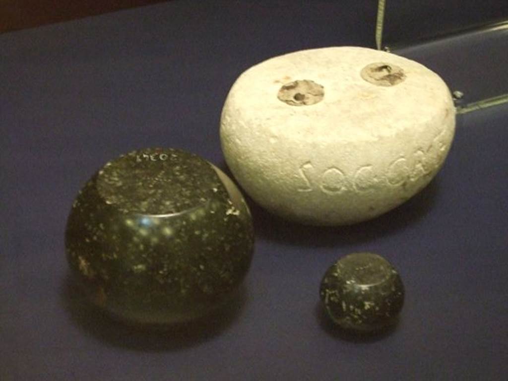 I.6.12 or I.6.13 Pompeii. Round white limestone weight. SAP inventory number 3918.  
The two other black basalt weights were found somewhere in Pompeii, the larger one has SAP 20349 on it. 
Photographed at “A Day in Pompeii” exhibition at Melbourne Museum where it is given as from I.6.13. September 2009.



