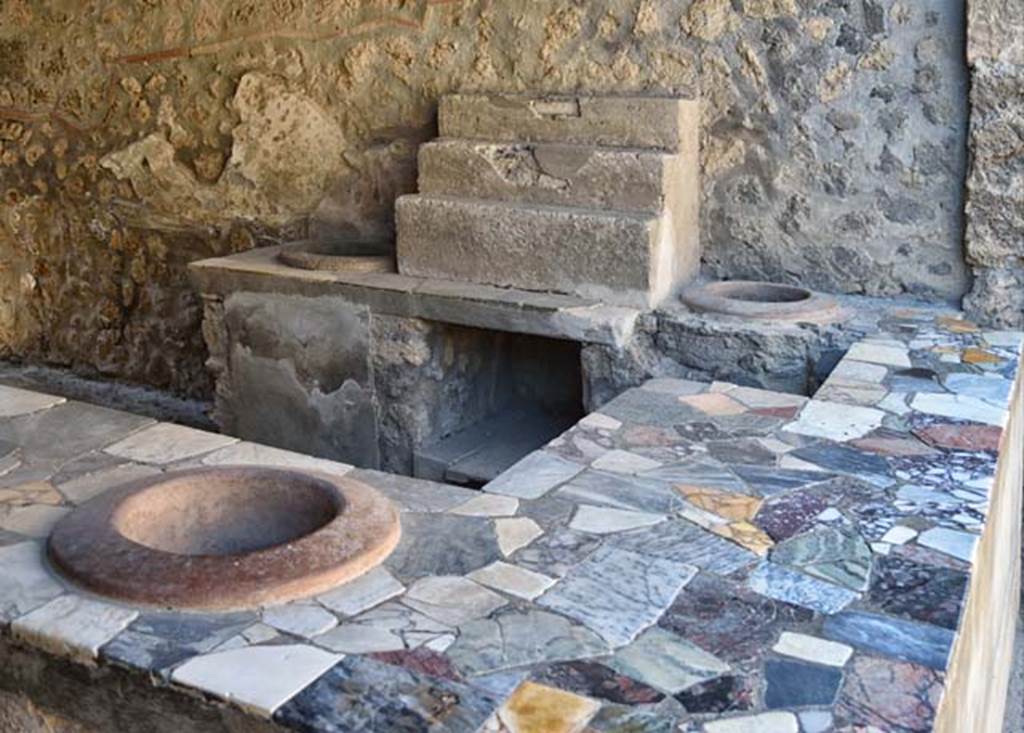 I.9.4 Pompeii. April 2018. Looking towards west wall with display shelving and two urns.
Photo courtesy of Ian Lycett-King. Use is subject to Creative Commons Attribution-NonCommercial License v.4 International.
