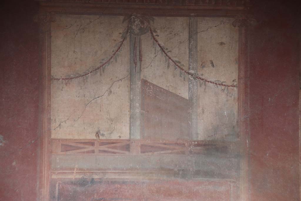 I.10.4 Pompeii. September 2021. Room 4, painted decoration on east wall from below centre painting. Photo courtesy of Klaus Heese.