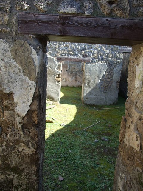 I.13.15 Pompeii. March 2009.  Room on north side of entrance. Doorway from room, looking east across central courtyard. 
 