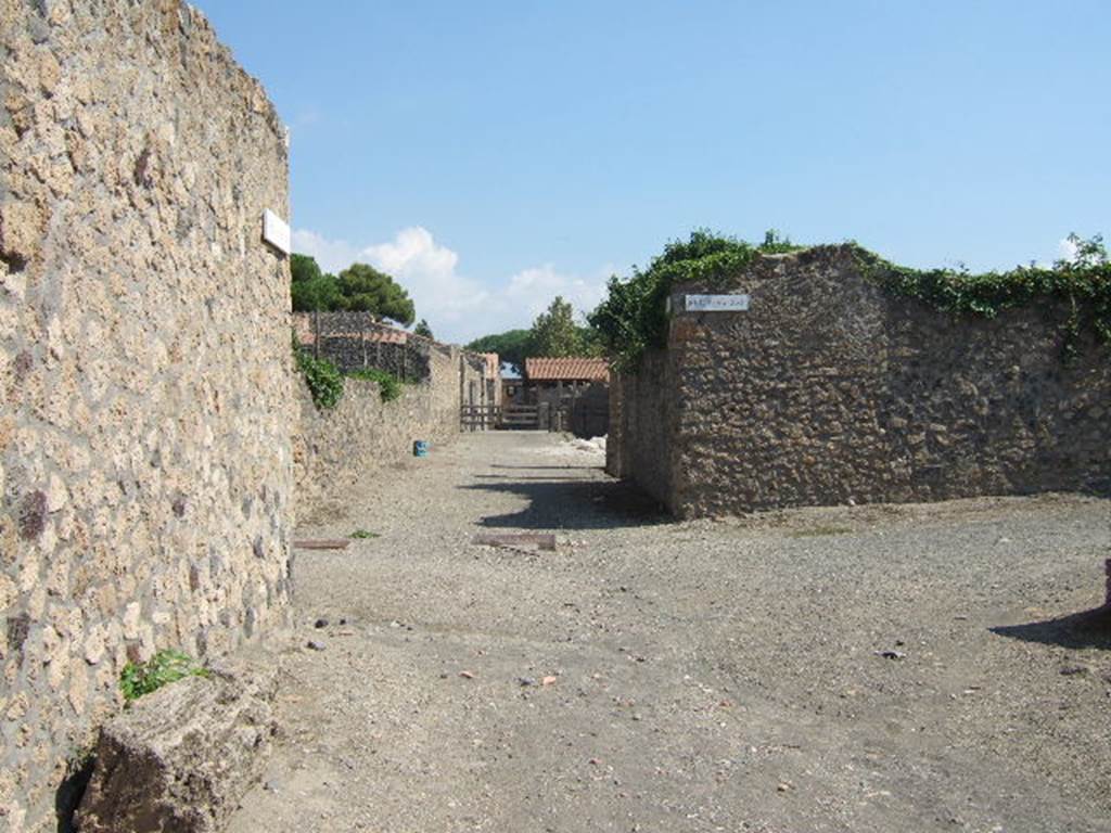 I.16.6 Pompeii, on left, September 2005. Via della Palestra, looking east at junction with Vicolo della Nave Europa. I.21, on right.