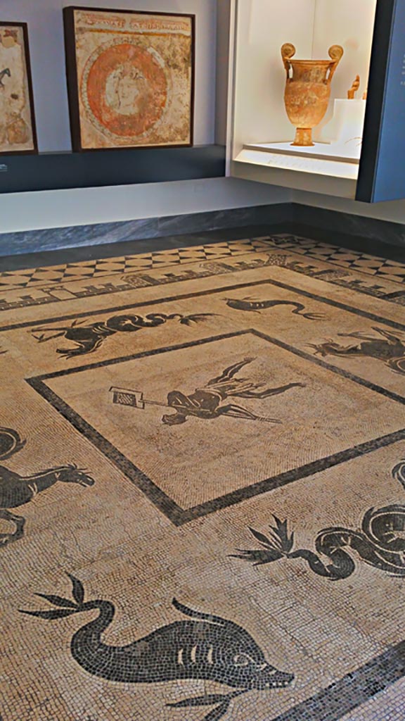 II.4.6 Pompeii. July 2019.  
Black and white mosaic from centre of floor showing a furnaceman and a marine scene set in floor of Naples Museum.
Photo courtesy of Giuseppe Ciaramella.

