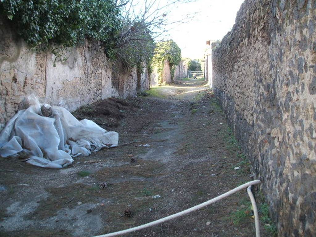 II.3 Pompeii.   December 2005.  Roadway looking North. Side wall of II.4.9