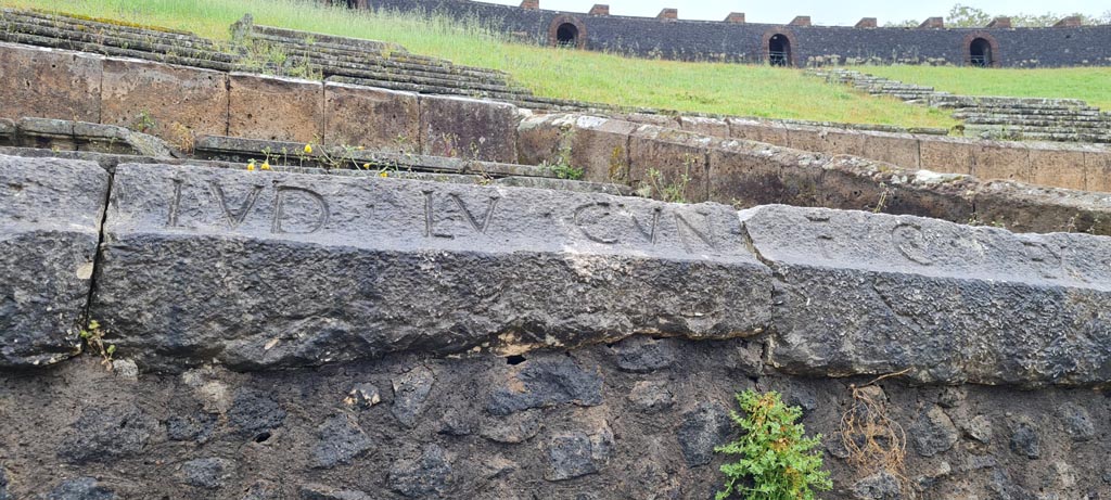 II.6 Pompeii. April 2022. Inscription carved on rim of inner wall of the arena of the amphitheatre -
Inscription LVD LV CVN, part of CIL X 854.
Photo courtesy of Giuseppe Ciaramella.
