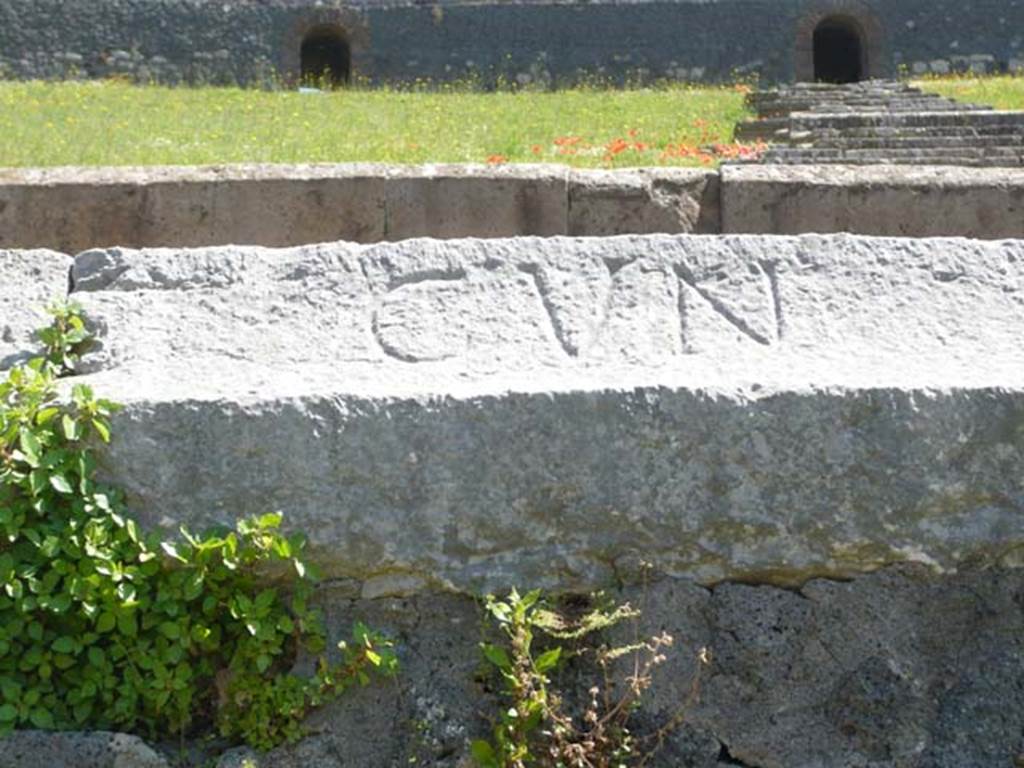 II.6 Pompeii. May 2012. Inscription CVN (cuneus) carved into rim of inner wall of the arena of the Amphitheatre.  
Photo courtesy of Buzz Ferebee 
According to Cooley, this relates to a particular section, or wedge, of seating (cuneus). 
See Cooley, A. and M.G.L., 2004. Pompeii: A Sourcebook. London: Routledge, p. 46.
