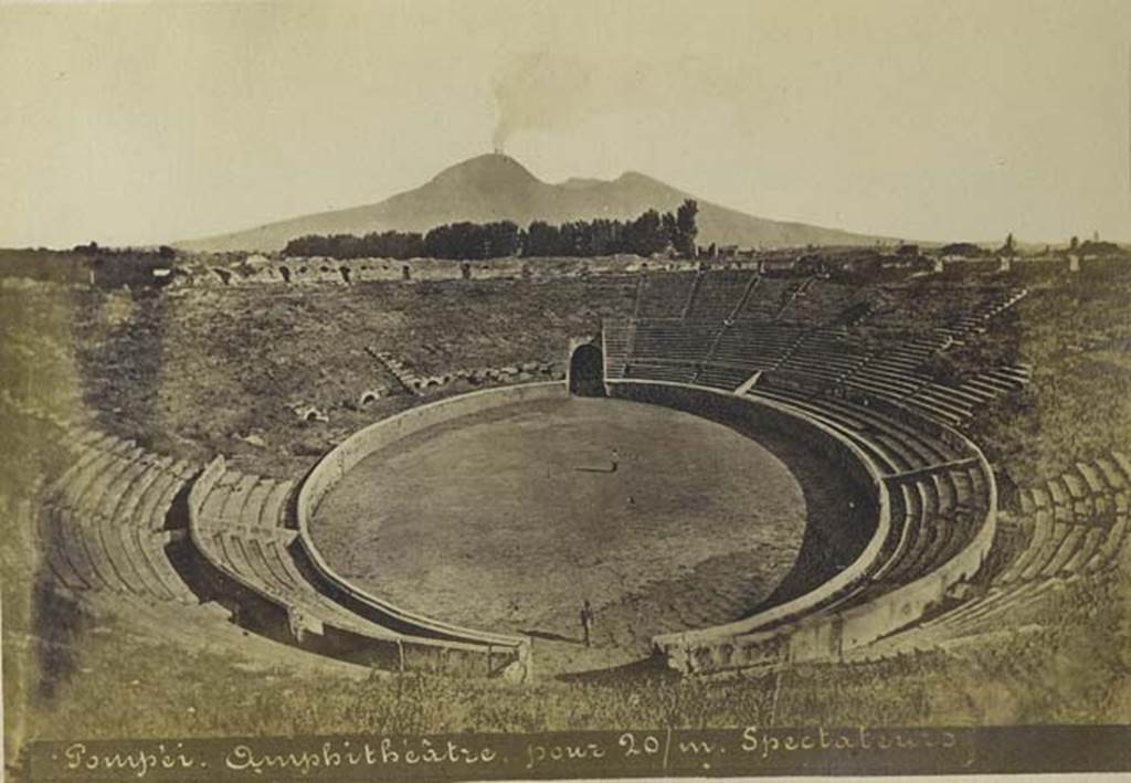 II.6 Pompeii. Old undated photograph by Mauri, no.024.  Looking north across amphitheatre to a smoking Vesuvius. Photo courtesy of Rick Bauer.
