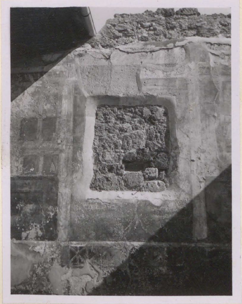 V.1.26 Pompeii. Pre-1943. Room o.
Looking towards east wall and recess remaining after the painting of Theseus abandoning Ariadne was removed and transferred to the museum. 
On either side of the recess, traces of architectural motifs can be seen.
See Warscher, T. 1942. Catalogo illustrato degli affreschi del Museo Nazionale di Napoli. Sala LXXXII. Vol.4. Rome, Swedish Institute

