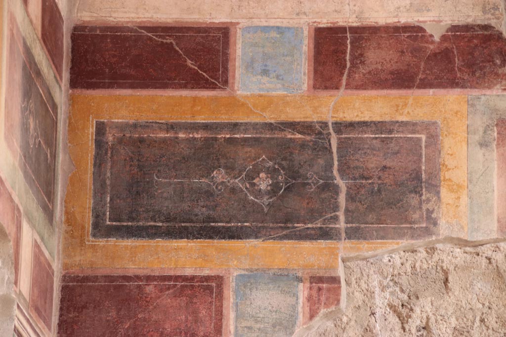 V.2.i Pompeii.  October 2023. 
Room 1, upper east wall at north end above doorway to room 3, detail of painted decoration. Photo courtesy of Klaus Heese.
