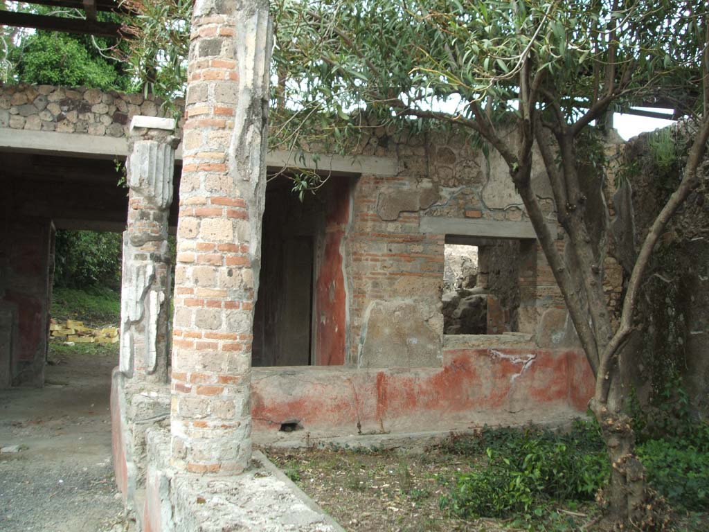 V.3.4 Pompeii. March 2009.  Tablinum on north side of portico, with three doorways and an aedicula lararium.

