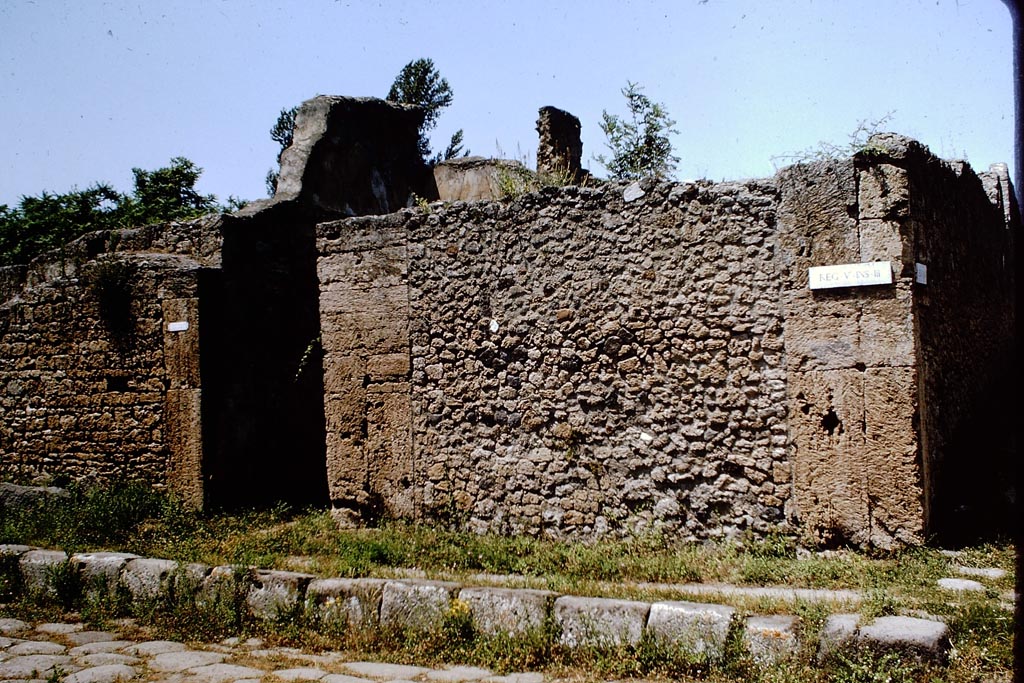 V.3.8 Pompeii. 1964. 
Exterior wall on east side of doorway, to junction with Vicolo di M.L. Frontone, on right. Photo by Stanley A. Jashemski.
Source: The Wilhelmina and Stanley A. Jashemski archive in the University of Maryland Library, Special Collections (See collection page) and made available under the Creative Commons Attribution-Non Commercial License v.4. See Licence and use details.
J64f1635
