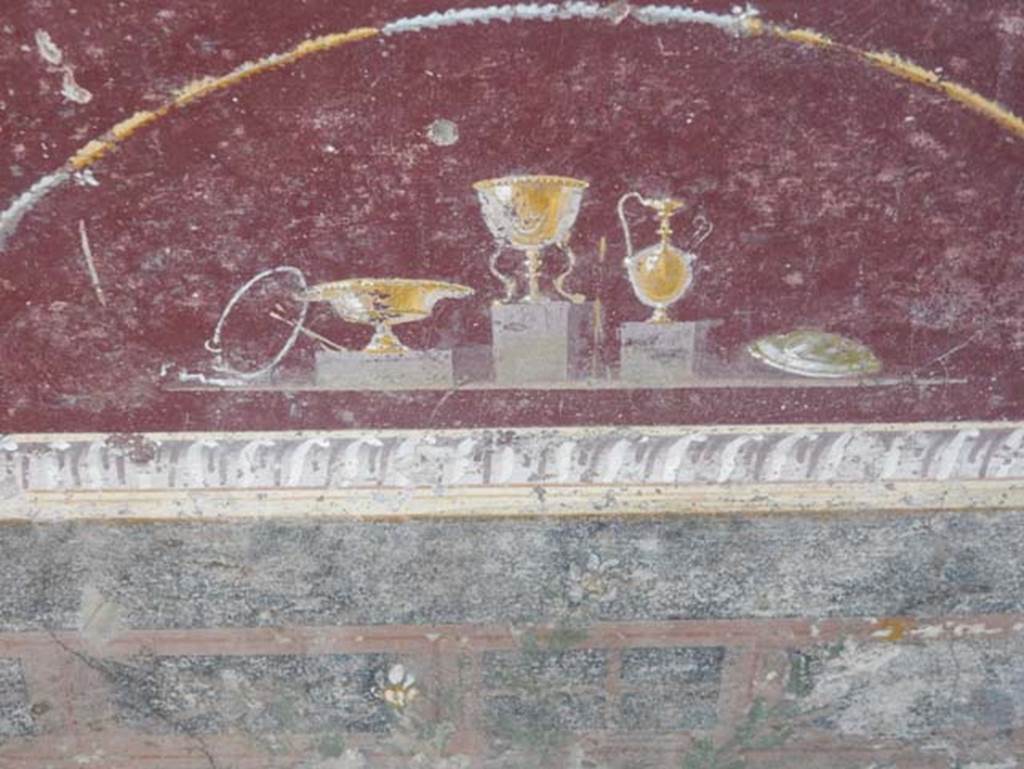 V.4.a Pompeii. May 2015. Detail of jugs and bowls from predella on east end of north wall in tablinum. Photo courtesy of Buzz Ferebee.
