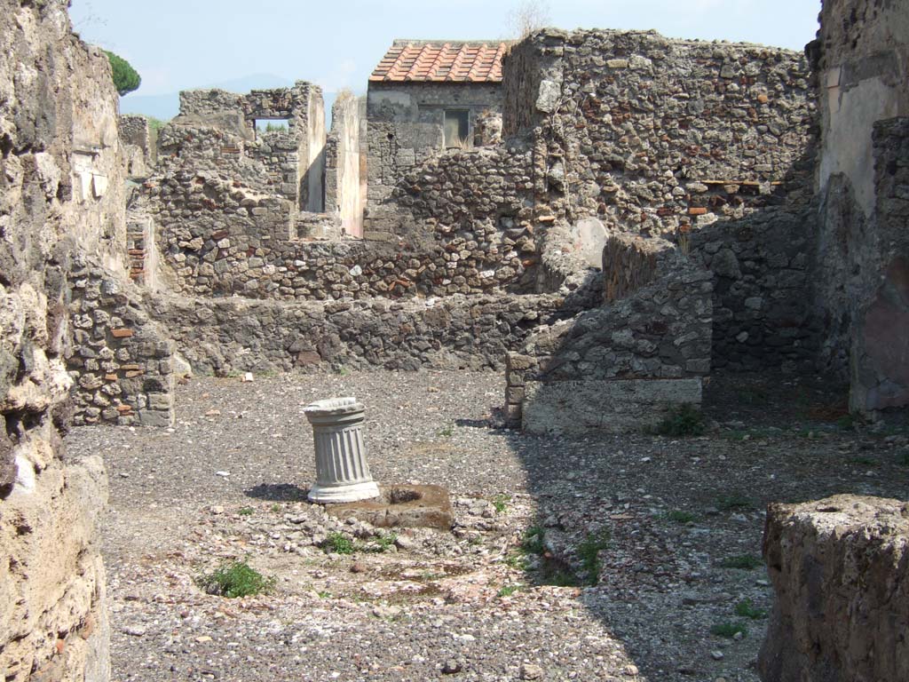 VI.2.17 Pompeii. September 2005. Looking east across atrium with impluvium, towards tablinum. 
For photos of the east part of this linked house, see VI.2.20.
According to Garcia y Garcia, in this house much damage was caused by the two bombs that fell on the nearby house to the north.
After the bombardment, it was left in a state of grave abandonment.
See Garcia y Garcia, L., 2006. Danni di guerra a Pompei. Rome: L’Erma di Bretschneider. (p.74).
