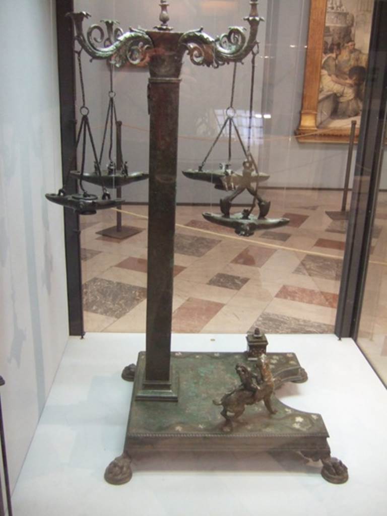 Bronze candelabrum with four volute branches for lamps.  Found in VI.6.1 House of Pansa.  Now in Naples Archaeological Museum.