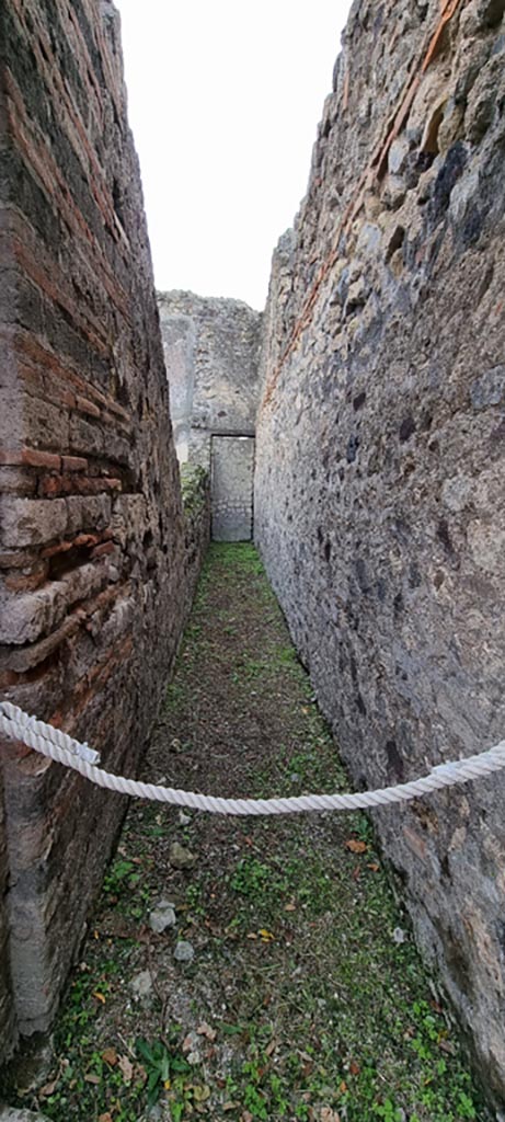VI.7.18 Pompeii. December 2023.
Corridor to blocked doorway into VI.7.1, on west side of triclinium. Photo courtesy of Miriam Colomer.

