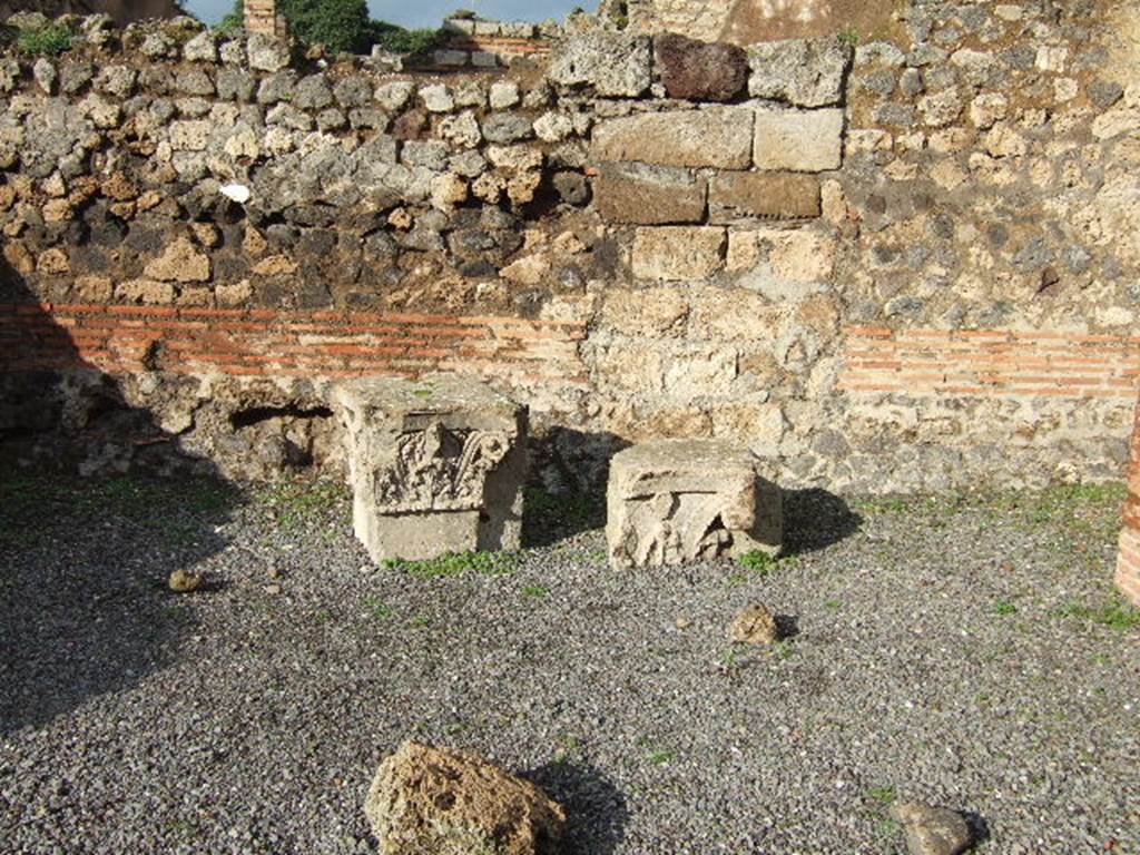 VI.10.15 Pompeii. December 2005. Two tufa capitals. These capitals were lodged here for safety, they most probably topped the pilasters of the vestibule of VI.10.14.
See Studi della Soprintendenza archeologica di Pompei, 12, (2006): Rileggere Pompei, I. Linsula 10 della Regio VI, ed by Coarelli and Pesando, Rome, LErma di Bretschneider, (p.345)
