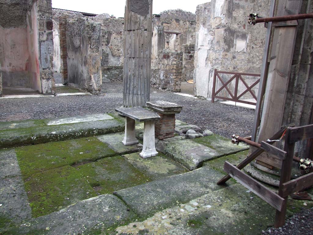 VI.11.10 Pompeii. December 2006. Atrium 27 with marble table, looking north-west. Stone ball is in cistern mouth.