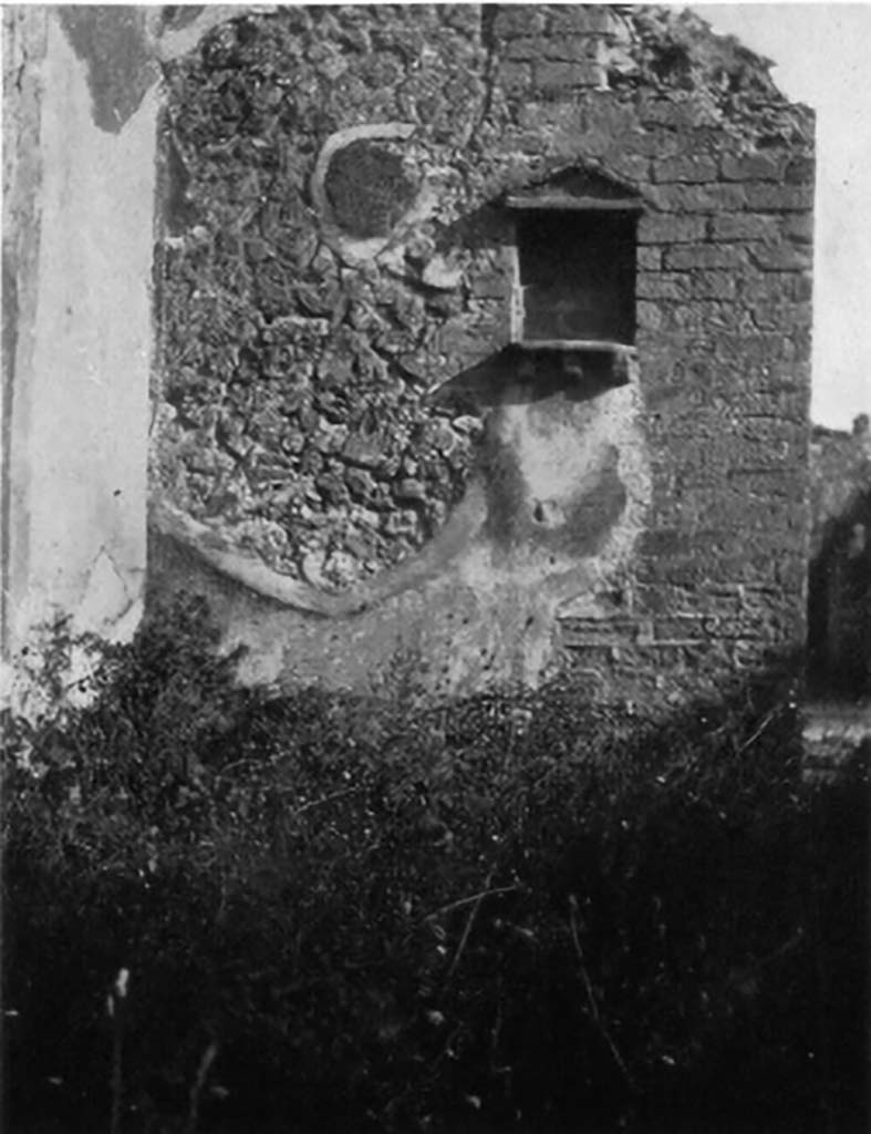 VI.14.5 Pompeii. 1930s photo of lararium by Tatiana Warscher.
According to Boyce, in the south wall of the atrium to the right of the entrance is a rectangular niche.
It is adorned with a pediment on the wall above it, and a ledge supported by three brackets, projects on the level of the floor.
These are all formed by tiles embedded into the wall and presumably all originally covered with stucco.
See Boyce G. K., 1937. Corpus of the Lararia of Pompeii. Rome: MAAR 14. (p.52, no.197, and Pl.1,3) 

