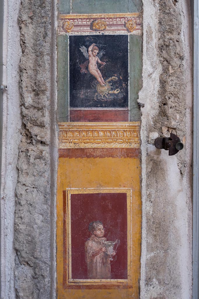 VI.15.1 Pompeii. March 2023. 
Painted panel on south end of west wall of atrium, leading onto peristyle. Photo courtesy of Johannes Eber.
