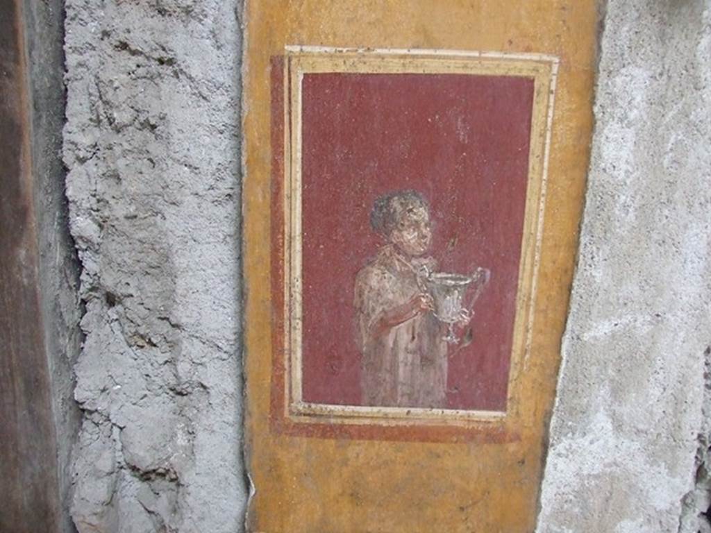 VI.15.1 Pompeii. December 2006.   Detail of painted pillar between Peristyle and Atrium with figure holding a cup.
