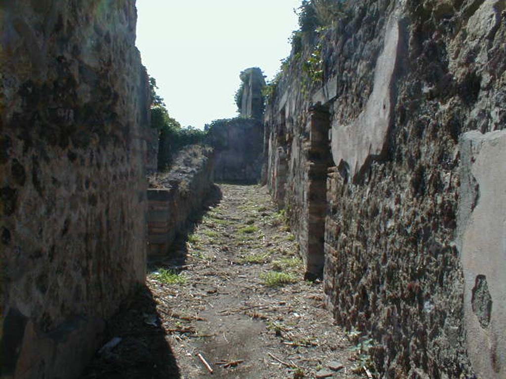 VI.15.14 Pompeii. September 2004. Looking west along entrance corridor towards atrium at its end.
On the left is the doorway to the garden area at the rear of VI.15.13.
On the right are two doorways linking with the rooms of VI.15.15.
