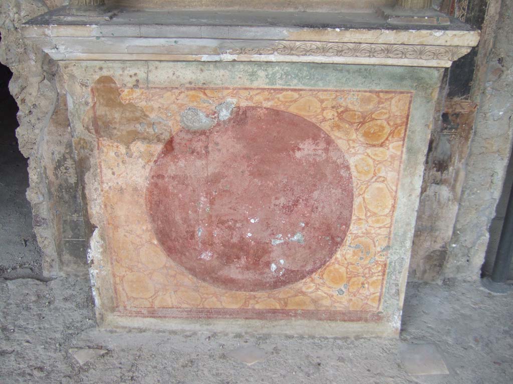 VI.16.7 Pompeii. May 2006. 
Room F, north portico. Lararium podium painted to represent red and yellow marble with a darker circle in front.
