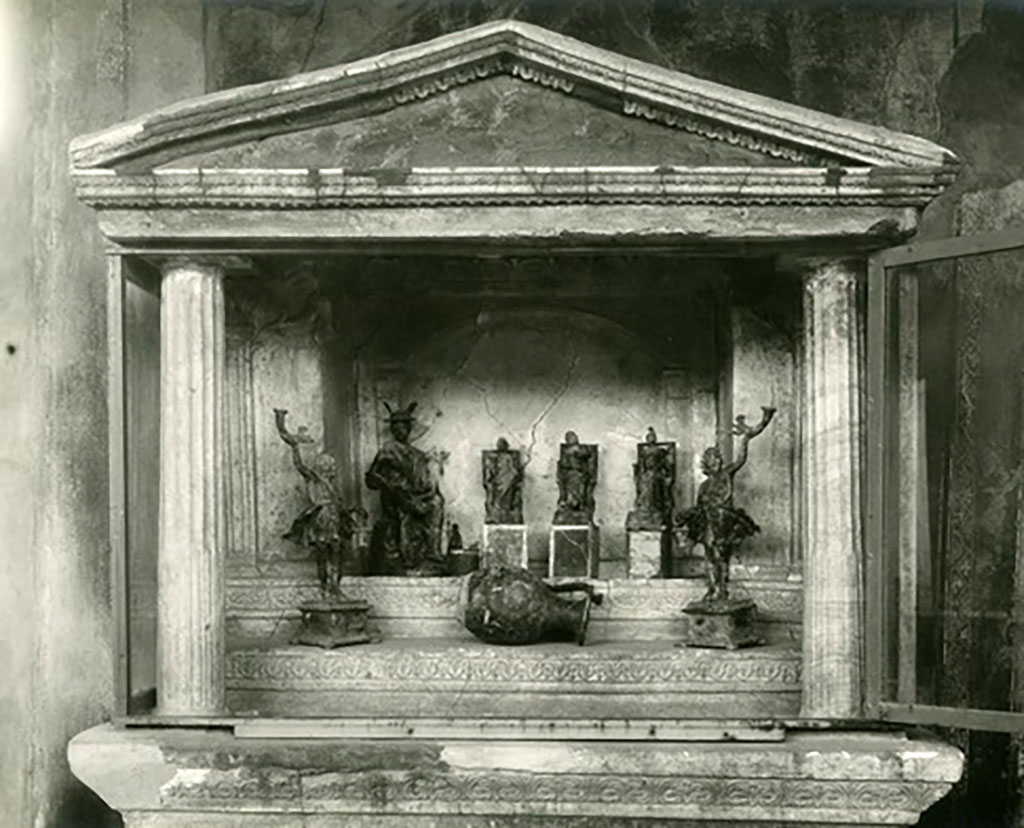 VI.16.7 Pompeii. Statues found in the lararium.  
Seated on the top step are Mercury, Juno, Jupiter and Minerva.  
The two Lares were placed, on either side of the group, but on the lower step.
Also found was a bronze vase in the shape of an oinochoe with a large belly, flat bottom, protruding lip and a handle set laterally to this.
Now in Naples Archaeological Museum. Inventory numbers 133323, 133324, 133325, 133327, 133328 (and 133326?).
See Boyce G. K., 1937. Corpus of the Lararia of Pompeii. Rome: MAAR 14, pp. 57-8, no. 221, and pl.38, 2.
See Notizie degli Scavi di Antichità, 1907, pp. 564-571, fig. 14.

