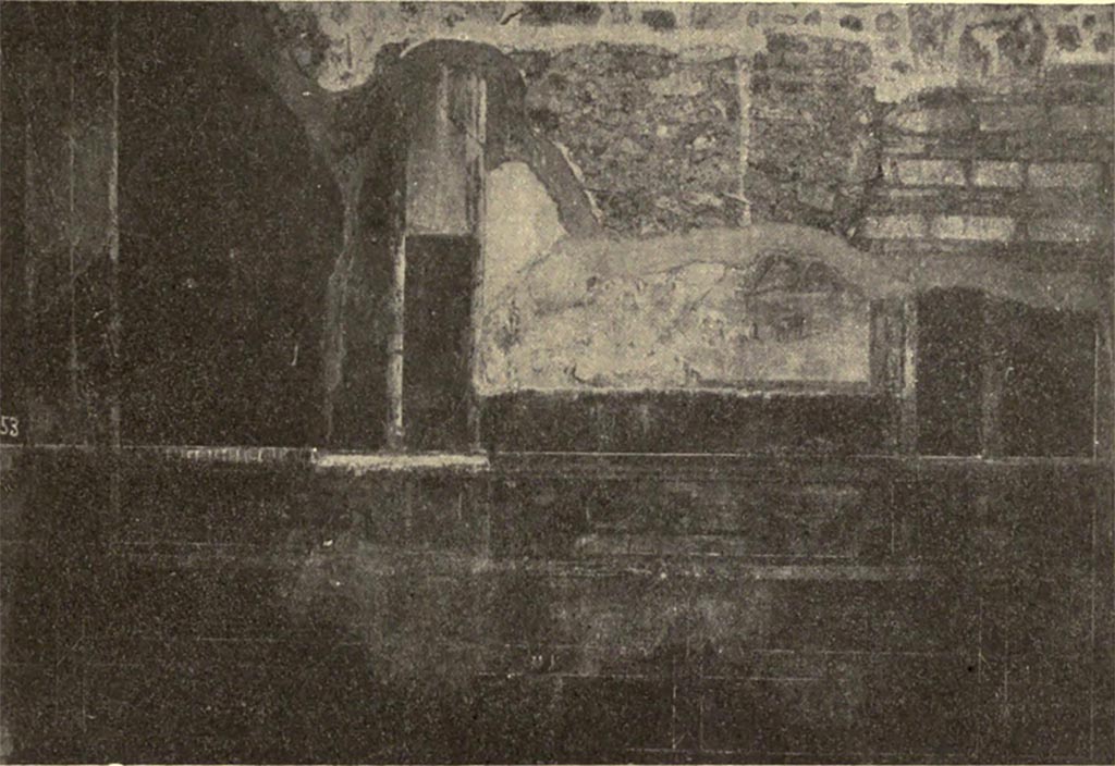 VI.16.7 Pompeii. c.1906. Room B, south wall showing painted decoration.
According to NdS, this south wall was the best preserved of the walls in the atrium.
It was divided into five large panels, however the one to the right was only a part-panel due to the doorway.
The larger central panel had a black background, whereas the others were painted red.
Only the lower part of the central painting (see above) was conserved (0.50m high x. 1.25m wide).
On a rock, on the right, sat a male figure, but only his left very dark leg remained.
His foot was fitted with a high boot with laces.
Leaning against the rock was a panpipe.
Nearby to the right, on the green pastureland were two lambs and a goat, forming a group; two goats formed another group on the left.
It was probable that the painting showed Paris grazing the flock on Ida.
See Notizie degli Scavi di Antichità, 1906, p.376-7, fig.2.
