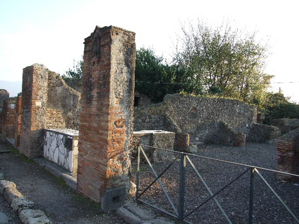 VI.17.4 left and VI.17.3 right, Pompeii. December 2006. The brick pilaster in the centre is the location of the plaque below.