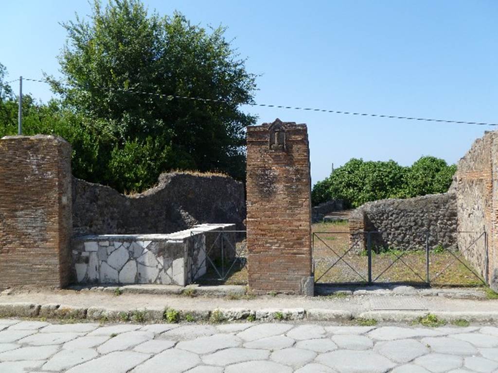 VI.17.4 left and VI.17.3 right, Pompeii. July 2010. The brick pilaster in the centre is the location of the plaque below. Photo courtesy of Michael Binns.