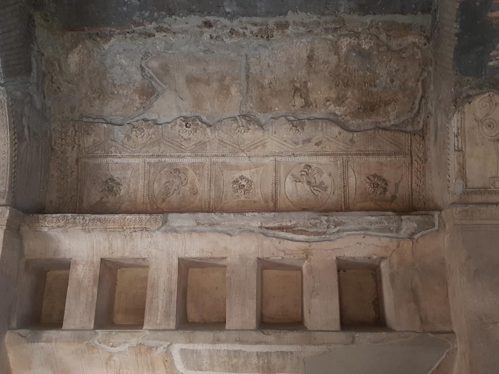 VII.1.8 Pompeii. October 2022. 
Centre of south wall, stucco decoration above niches for belongings in men’s changing room 2. Photo courtesy of Klaus Heese.
