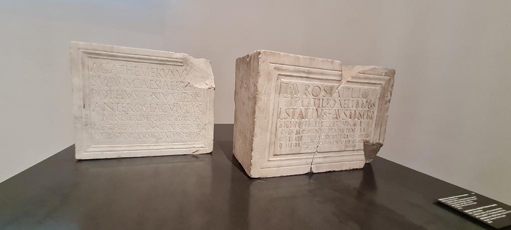 VII.4.1 Pompeii. April 2023. Two white marble bases, found February 1824 in the cella.
On display in “Campania Romana” gallery in Naples Archaeological Museum, inv.3768 on left, and inv. 3769 on right.
Photo courtesy of Giuseppe Ciaramella.

On left: Tempio della Fortuna Augusta, cella (23 febbraio 1824)
Agathemerus Vetti
Suavis Caesiae Primae
Pothus Numitori
Anteros Lacutulani
minist(ri) prim(i) Fortun(ae) Aug(ustae) iuss(u)
M(arci) Stai Rufi Cn(aei) Melissaei d(uum)v(irorum) i(ure) d(icundo)
P(ublio) Silio L(ucio) Volusio Saturn(ino) co(n)s(ulibus)      [CIL X, 824]

On right: Tempio della Fortuna Augusta, cella (23 Febbraio 1824)
Tauro Statilio,
Ti(berio) Platilio Aelian(o) co(n)s(ulibus),
L(ucius) Statius Faustus pro
signo, quod e lege Fortunae
Augustae ministorum ponere 
debebat, referente Q(uinto) Pompeio Amethysto
quaestore, basis duas marmorias decrever[u]ṇt
pro signo poniret.      [CIL X, 825]
