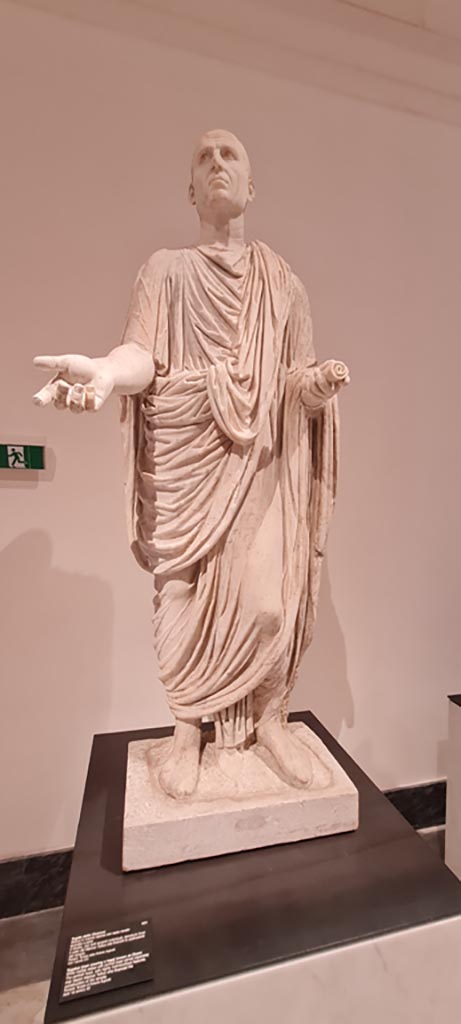 VII.4.1 Pompeii. April 2023. White marble statue of man wearing a toga known as Cicero but may depict Marcus Tullius who financed the construction of the temple.
On display in “Campania Romana” gallery in Naples Archaeological Museum, inventory number 6231.
Photo courtesy of Giuseppe Ciaramella.

Photo courtesy of Giuseppe Ciaramella.

