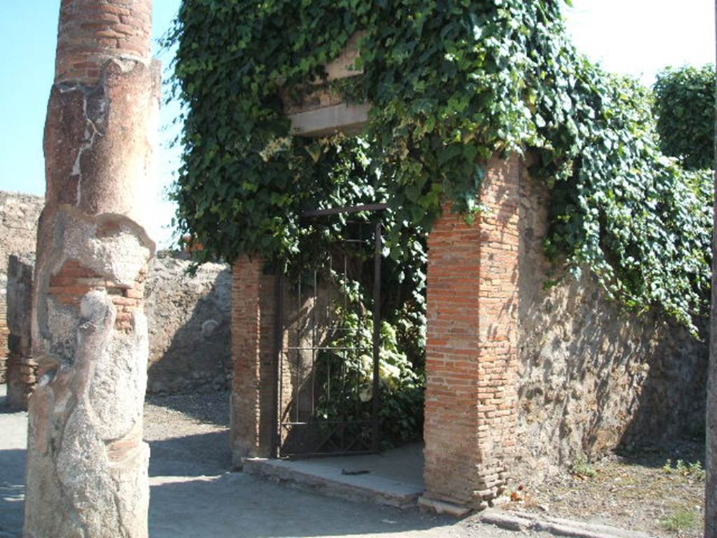 VII.4.10 Pompeii. September 2005. Entrance
According to Gell –
“Nearly opposite the entrance to the Baths, which occupies the centre of this street on the left-hand side, is a house on the right hand-side of more consequence than the rest. It has received the name of the House of Bacchus, from a large painting of the god yet existing on a wall opposite the entry.
Canals for the introduction of water are found in the Atrium, which has been surrounded by a small trough, or parterre of natural flowers, the side of which next the eye is painted blue, to represent water on which boats are floating. The wall behind this is painted with pillars, between which run balustrades of various forms, and upon these perch cranes and other birds, not badly painted, with a background of reeds or plants, and a sky visible behind. The effect must have been pretty when the whole was perfect.  In the same house is the picture of a male and female sitting at the base of a pillar, attended by three cupids. In the background is a tree, with mountains in the distance. Nothing can exceed the grace of these figures in the original, and on that account, an outline of the picture has been, among others, selected for this work. See Plate XII (and see below).
In the same house is a pavement of coloured marbles, in the nature of opus Alexandrinum, which is pretty and is therefore given at the end of this work in Plate LXXXVIII.”
See Gell, W, 1832.  Pompeiana: Vol 1.  London: Jennings and Chaplin, (p.39-40)

