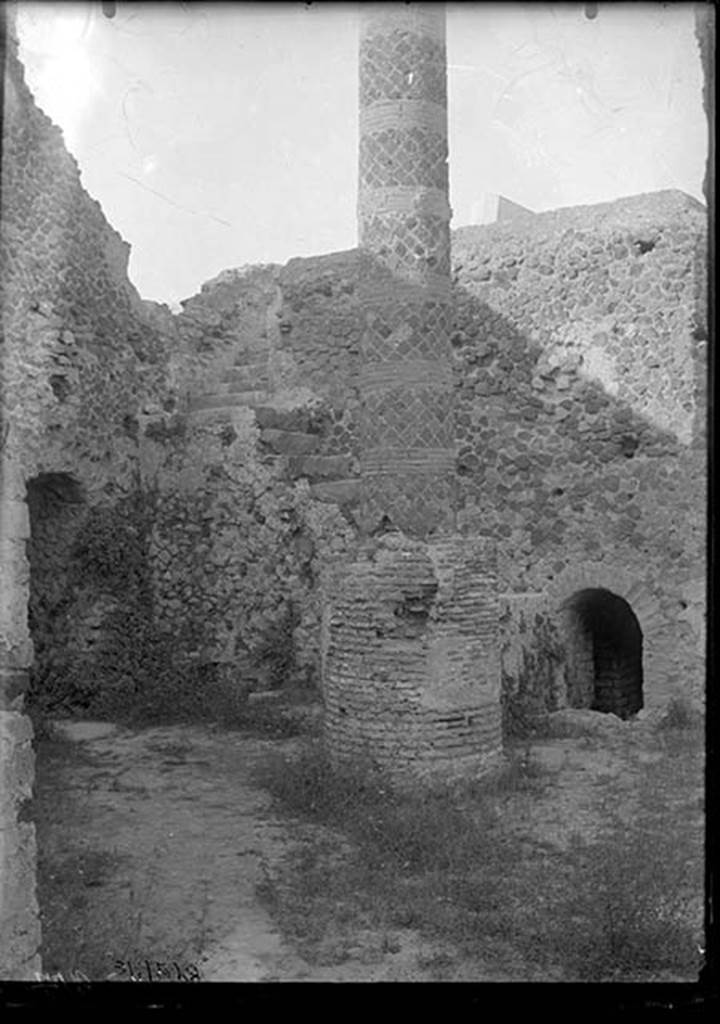 VII.5.10 Pompeii. 1931. Courtyard (33) with column (34), staircase (35) to caldarium, and entrance (36) to praefurnium (boiler) area.
DAIR 31.2528. Photo © Deutsches Archäologisches Institut, Abteilung Rom, Arkiv. 
The courtyard is accessible off Vicolo delle Terme.
On the left is the entrance corridor (32) to the praefurnium.
The ramped masonry staircase (35) allows access to the roof of the caldarium.
The circular brick base had a column (34) erected on it after the earthquake, probably to support a sundial.
The smaller arch on the right is entrance (36) to praefurnium (boiler) area.
See Carratelli, G. P. ed., 1990-2003. Pompei: Pitture e Mosaici. Vol. VII. Roma: Istituto della enciclopedia italiana, p. 172. 

Alternative sources, such as Niccolini, have suggested the column is a roof support.


