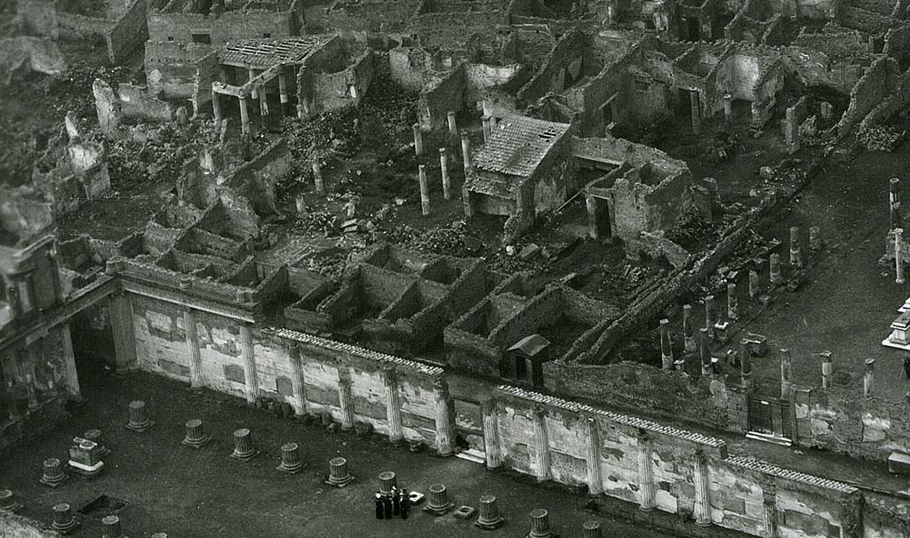 VII.7.10 Pompeii. 1944, detail taken from USAAF aerial photo.
Looking north-west across the Basilica and Via Marina, lower left in photo.
On the north side of the Via Marina, in the upper part of the photo, the house of House of Romulus and Remus (VII.7.10), and House of Tryptolemus (VII.7.5 and VII.7.2) can be seen on the west side of the Temple of Apollo, which is on the right. Photo courtesy of Rick Bauer. 

