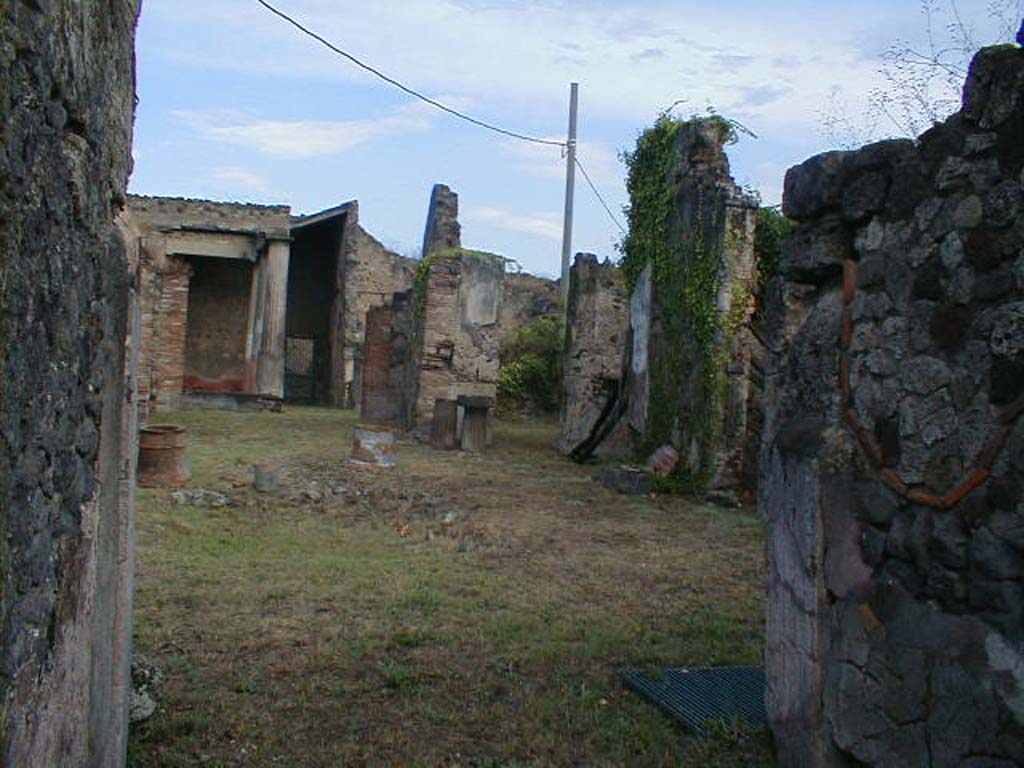 VII.7.10 Pompeii. September 2004. Looking north-east across atrium, from entrance fauces.
According to Della Corte, near the oecus (n) on the east side of the tablinum, skeletons of two men, a boy and two dogs were found.
One of the adult skeletons had a gold ring on a finger on his left hand, and another of bronze with the wording FA-H. He also had a lot of money on him.
Della Corte without hesitation interpreted his name as Fa(bius) H…….
See Della Corte, M., 1965. Case ed Abitanti di Pompei. Napoli: Fausto Fiorentino. (p.218, S.43 = C.X.8058)
