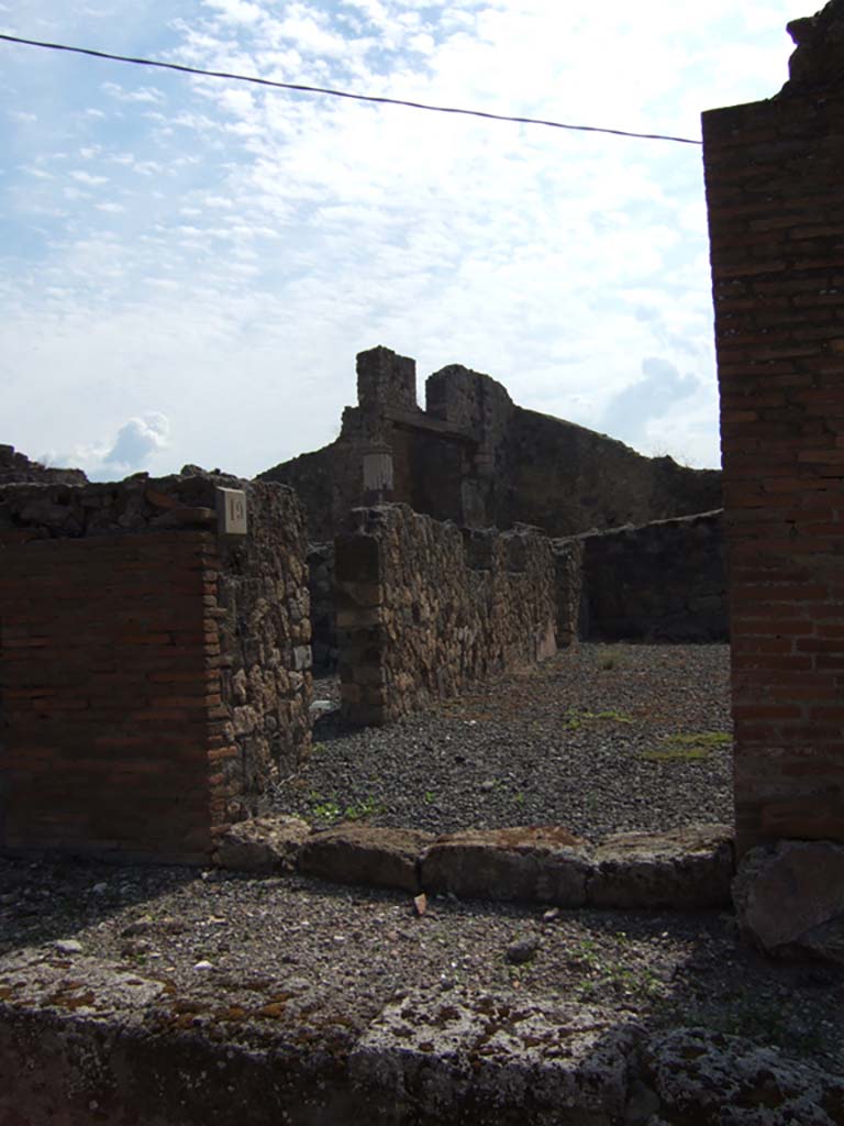 VII.7.19 Pompeii. September 2005. Looking south to entrance doorway.
According to Garcia y Garcia, due to the bombardment in 1943, a part of the atrium and two nearby rooms were destroyed.
The destruction caused the loss of plaster and fourth style decoration.
See Garcia y Garcia, L., 2006. Danni di guerra a Pompei. Rome: L’Erma di Bretschneider. (p.116).
