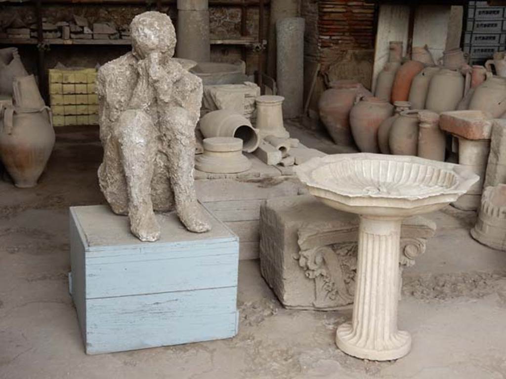 VII.7.29 Pompeii. May 2015. Plaster cast of body, basin, capital and other items in storage. Photo courtesy of Buzz Ferebee.
