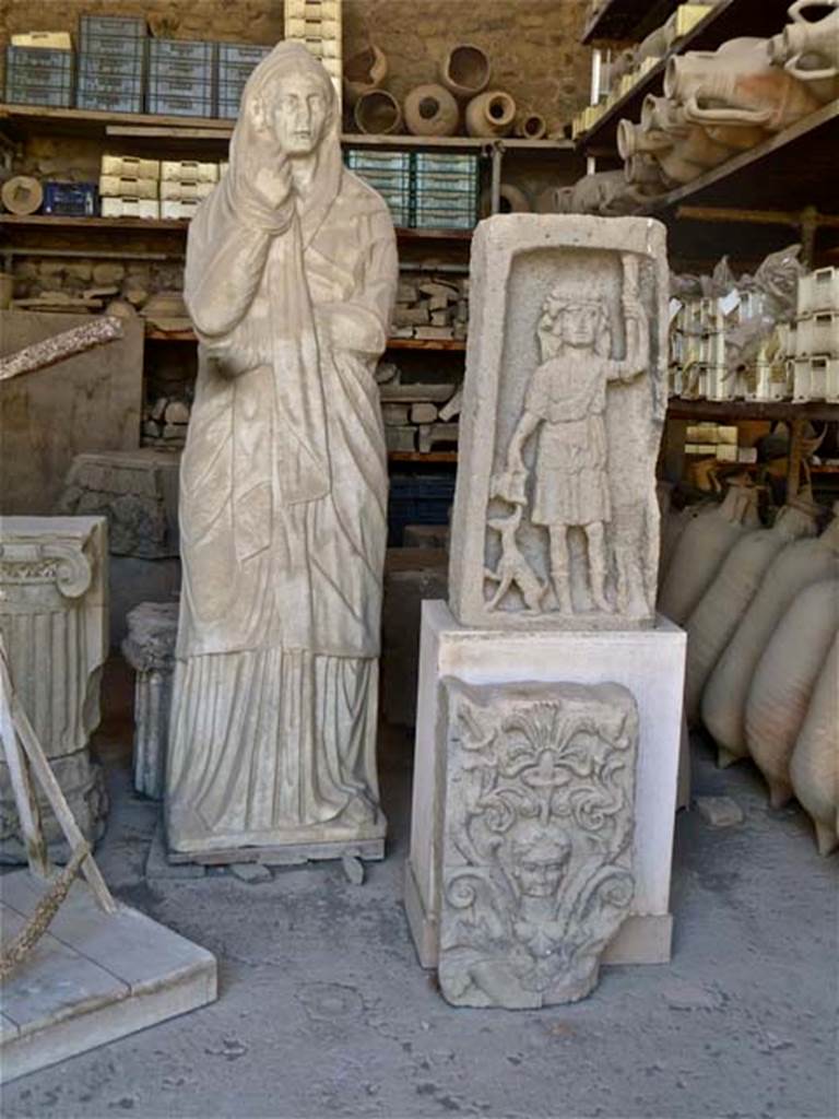 VII.7.29 Pompeii. May 2011. Statue, plaque and rectangular sculpture of Dionysus in storage. Photo courtesy of Michael Binns.