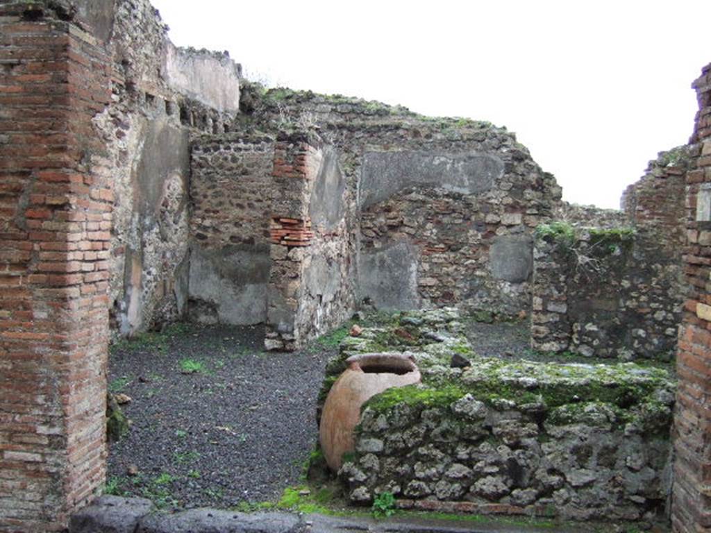 VII.13.20 Pompeii. December 2005. Looking east across bar-room with two-sided counter and remains of four urns and hearth.