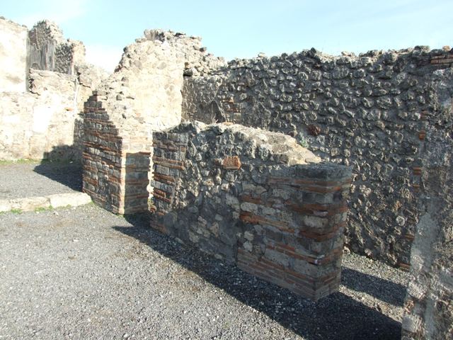 VII.14.6 Pompeii.  Shop.  East wall with doorway to latrine under staircase at VII.14.7.