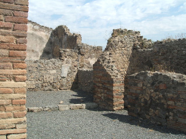 VII.14.6 Pompeii.  Shop.  East wall with doorway to latrine.

