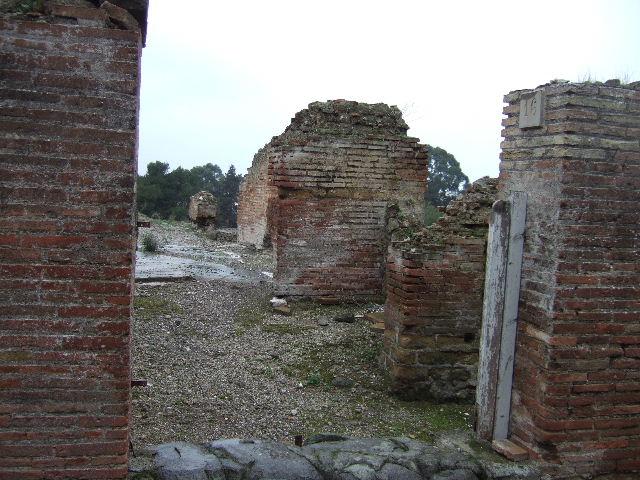 VII.16.16 Pompeii. September 2004.  Ahead is a doorway to the atrium of VII.16.15, the entrance to VII.16.16 is a turn to the right.
