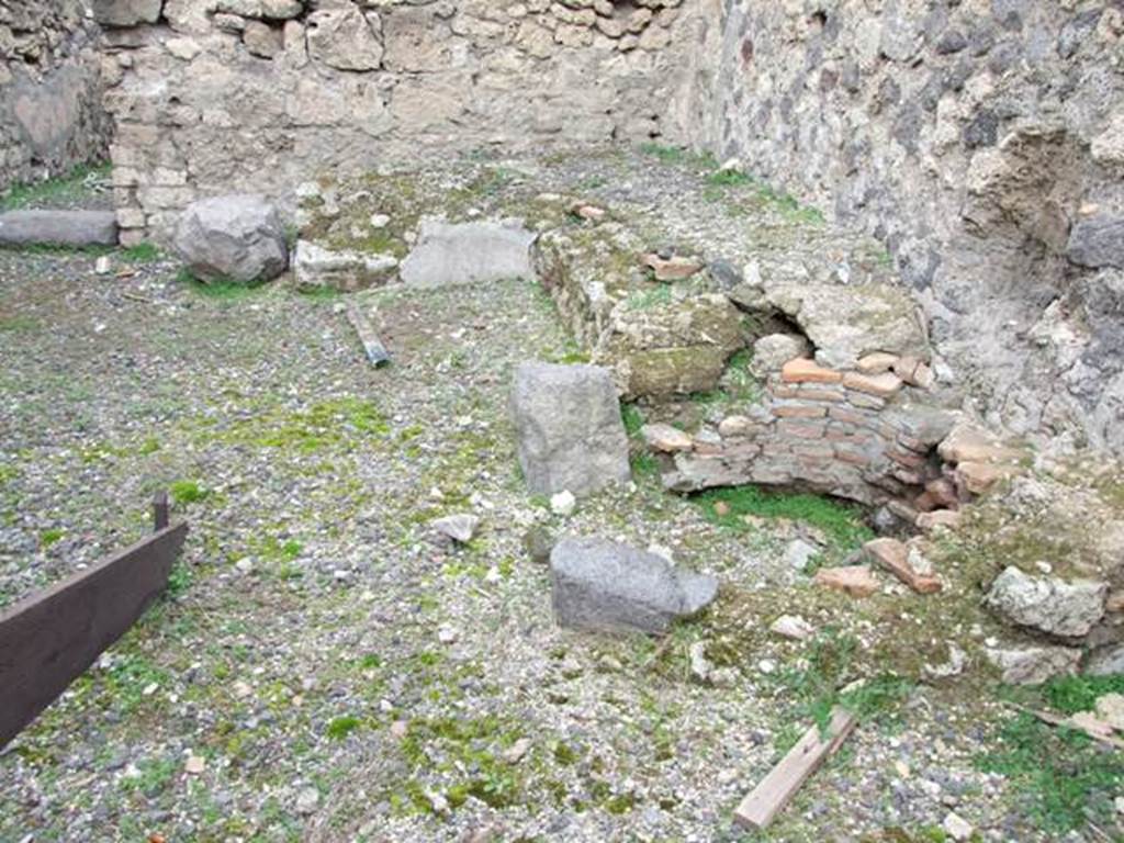 VIII.4.35 Pompeii.  Shop and room.  December 2007.  North east corner of shop.  Remains of two sided podium or counter with a furnace and tub.