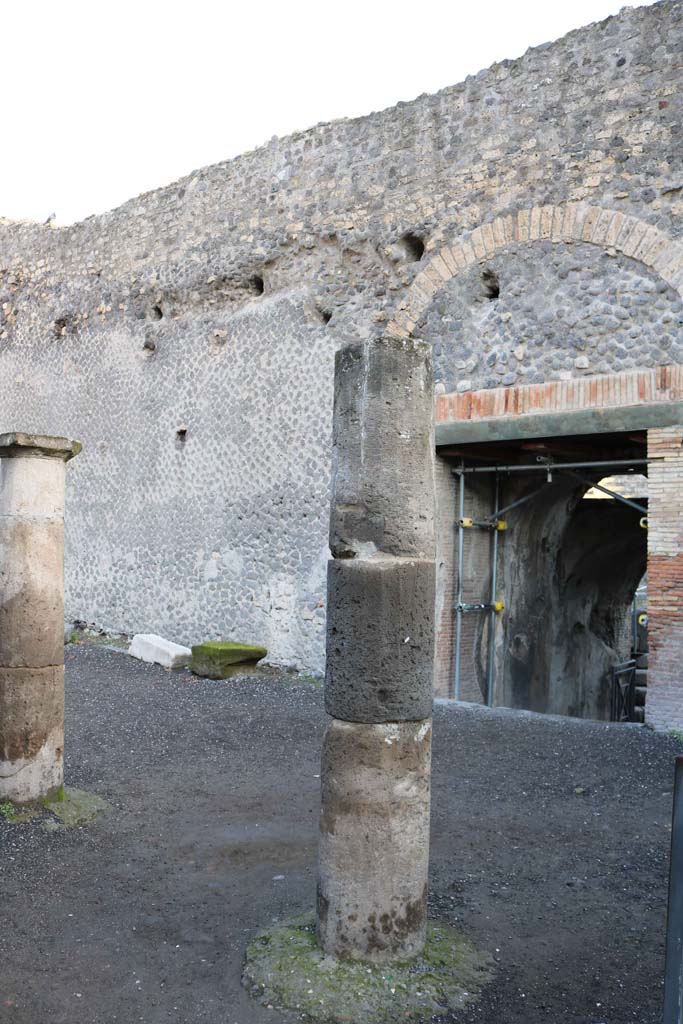 VIII.7.19 Pompeii. August 2021. 
Looking towards west side near entrance/exit, with statue of Kneeling Atlas, with a tufa Lion’s foot in front. Photo courtesy of Robert Hanson.

