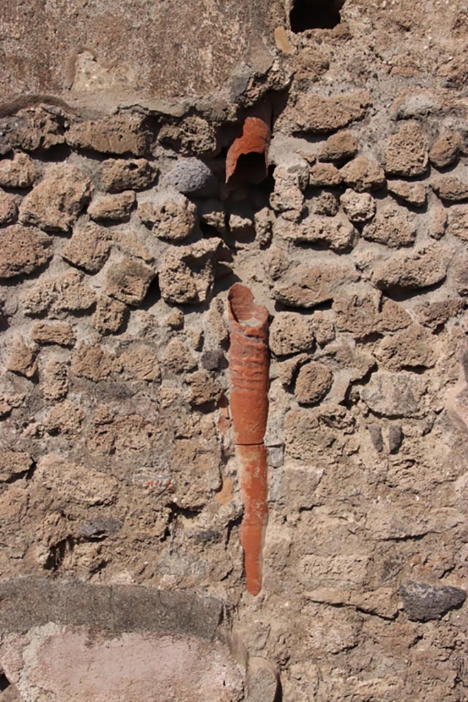 IX.1.1 Pompeii. October 2022. 
Downpipe in north wall, from upper floor. Photo courtesy of Klaus Heese.

