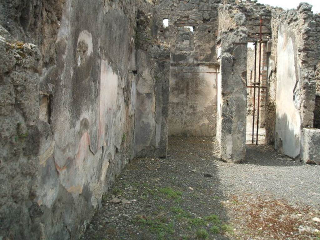 IX.8.b Pompeii. May 2005. Looking west along south wall of atrium, towards cubiculum on south side of entrance fauces. The site of the lararium niche can just be seen in the south wall, in front of the wall of the cubiculum.
